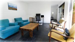 a living room with blue couches and a table and chairs at Fully Furnished Apartment in Parkwood in Johannesburg