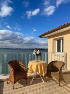 a table with two chairs and a vase of flowers on a balcony at Views on Venice Lagoon in Lido