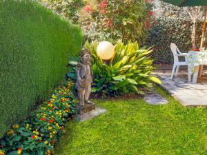 a statue in the middle of a garden with flowers at Villino Alborella in Verbania