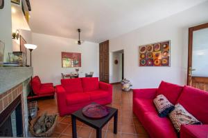 a living room with red couches and a fireplace at Villino Alborella in Verbania