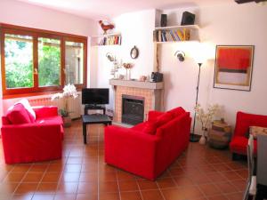 a living room with red chairs and a fireplace at Villino Alborella in Verbania