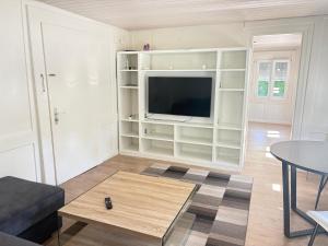 Una sala de estar con un televisor y una mesa. en Charmante 2-Zimmer EG Wohnung in Heiden, en Heiden