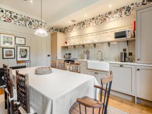 a large kitchen with a table and chairs at Uk47811 - Baillies Cottage in Kinloch Rannoch
