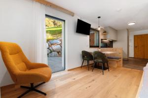 a living room with chairs and a table and a window at Mountain Chalet Tribulaun Pflersch in Colle Isarco