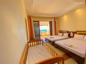 a bedroom with two beds and a balcony at Shanzu Oceanfront Apartments and Suites in Mombasa +30 photos