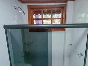 a bathroom with a glass shower and a window at Casa de Temporada Allamanda in Água Boa +44 photos