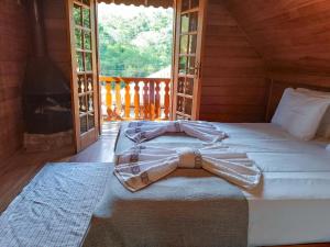 a bed with a bow tie on it in a room at Casa de Temporada Allamanda in Água Boa