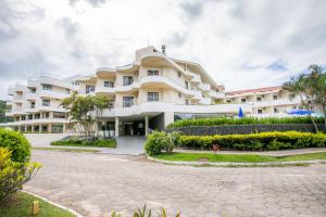 a large white building with a courtyard at Hotel Praia Brava in Florianópolis