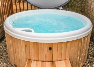 Una bañera de hidromasaje en un patio con un inodoro. en Laxfield Lodges, en Laxfield 10 fotos más