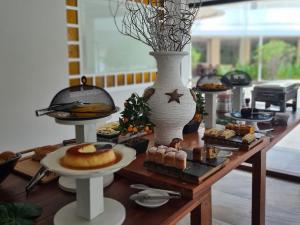 a table topped with different types of pastries and cakes at Hotel Praia Brava in Florianópolis