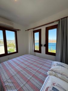 a bedroom with two windows and a bed with a bedspread at aura residence in Bodrum City