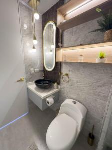 a bathroom with a white toilet and a sink at Top views, airport, Salitre, American embassy, parking in Bogotá +62 photos