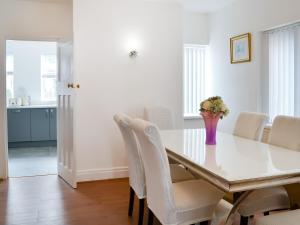 a dining room with a white table and white chairs at Rose And Jay House in Bridlington