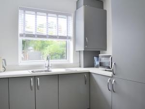 a white kitchen with a sink and a window at Rose And Jay House in Bridlington