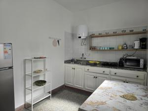 a kitchen with white cabinets and a refrigerator at KARAZ Homestay Grand appartement avec rooftop in Monte ʼArrouit