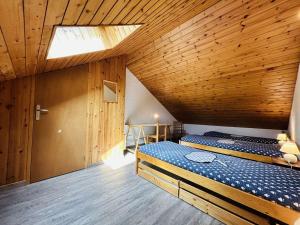 1 dormitorio con 2 camas en un techo de madera en Spacieux Triplex 4 pièces, 7 couchages, proche pistes, parking, calme - FR-1-330F-74, en Le Monêtier-les-Bains