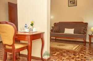 a living room with a table and a couch at Pinetree Gardens Residence in Eldoret +10 photos