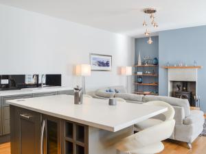 Una cocina y una sala de estar con una mesa y sillas blancas. en Eleanor Cottage, en Ballater