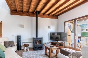 a living room with a fireplace and a tv at House with garden and fireplace in Osséja
