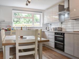 a kitchen with a table and a sink and a counter at Greenbank Cottage in Great Torrington