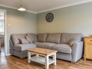 a living room with a couch and a table at Greenbank Cottage in Great Torrington