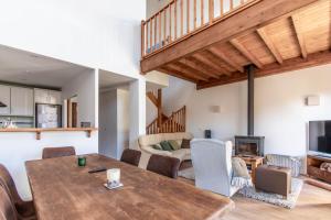 a dining room with a table and chairs and a living room at House with garden and fireplace in Osséja