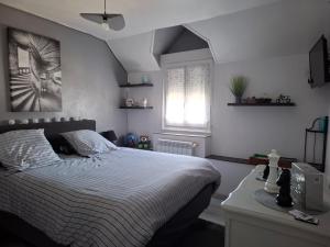 a bedroom with a white bed and a window at Chambre avec SDB privative et parking MOTO ou VL in Romorantin