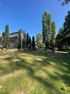 a house with a large yard with trees at Gites la Rifflais - L'étang - vue sur étang privé in Langrolay