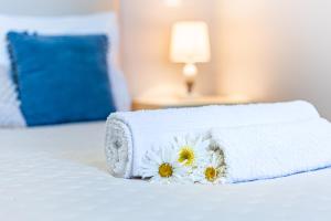a bed with white towels and flowers on it at Estrela house II Calheta Madeira in Calheta