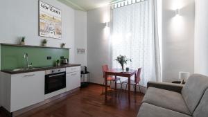 a kitchen and living room with a table and a couch at Italianway - Tadino 1 B in Milan