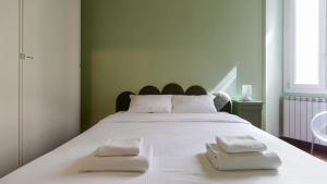 a large white bed with two white towels on it at Italianway - Tadino 1 B in Milan