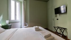 a bedroom with a white bed with towels on it at Italianway - Tadino 1 B in Milan