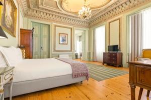 a bedroom with a bed and a desk and a television at Tesouro da Baixa by Shiadu in Lisbon