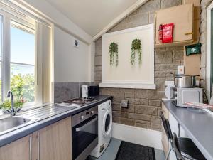 a kitchen with a sink and a dishwasher at Greystones Nawab Annex C in Monyash