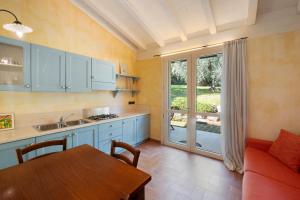a kitchen with blue cabinets and a table and a dining room at Agriturismo Il Cardo in Soiano del Lago