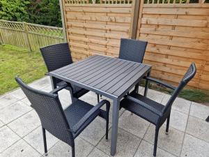 a black table and chairs on a patio at NEU! Ferienwohnung Ankerplatz Hooksiel in Hooksiel