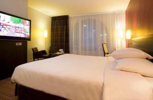 a hotel room with a large bed and a flat screen tv at Ibis Styles Metz Centre Gare in Metz