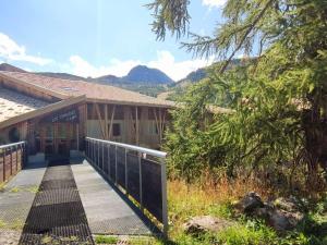 a building with a walkway in front of it with mountains at Appartement cosy sud, 4 pers, près du funiculaire - FR-1-292-197 in Isola