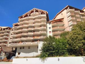 a tall apartment building with trees in front of it at Appartement rénové plein sud près des pistes avec parking - FR-1-292-189 in Isola