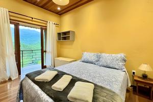 a bedroom with a bed with two towels on it at Studio Lua Nova - Cabanas Lua Nova in Penedo