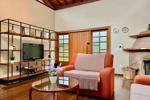 a living room with a couch and a tv at Studio Lua Nova - Cabanas Lua Nova in Penedo