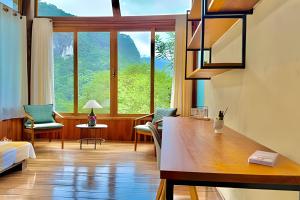 a room with a desk and a large window at Studio Lua Nova - Cabanas Lua Nova in Penedo