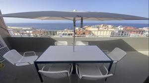 a table and chairs with an umbrella on a balcony at Atico ULISES in Valle Gran Rey