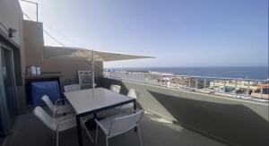 a table and chairs on a balcony with the ocean at Atico ULISES in Valle Gran Rey