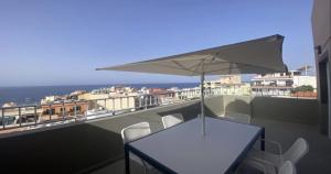 a table and chairs on a balcony with an umbrella at Atico ULISES in Valle Gran Rey