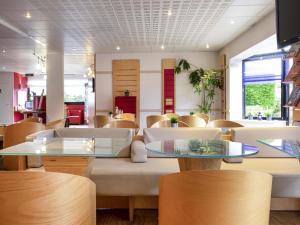 a restaurant with tables and chairs in a room at ibis Quimperle in Quimperlé