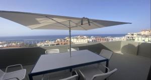 a table and chairs on a balcony with an umbrella at Atico ULISES in Valle Gran Rey +39 photos