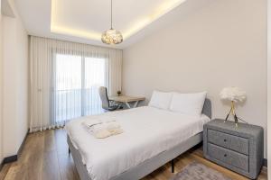 a bedroom with a large white bed and a desk at Utopia Suites in Burunabat +26 photos