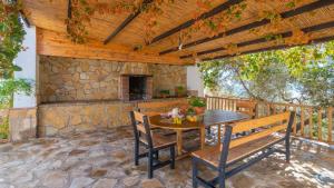an outdoor patio with a table and a stone fireplace at Casa La Sombra de la Parra Antequera - La Higuera by Ruralidays in Antequera