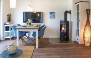ein Wohnzimmer mit einem Tisch und einem Holzofen in der Unterkunft Ocean's Twenty-One in Tossenserdeich
